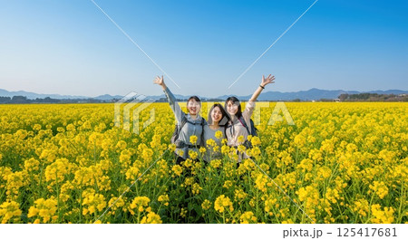 菜の花畑でハイキングする人達 125417681