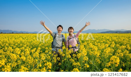 菜の花畑でハイキングする人達 125417682