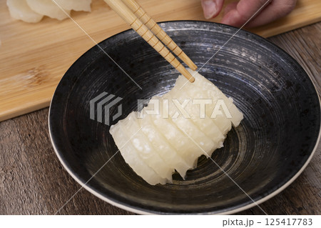 べったら漬けを包丁切る 125417783