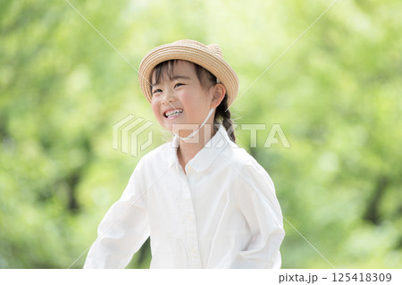 新緑の中屋外で笑顔の女の子 125418309