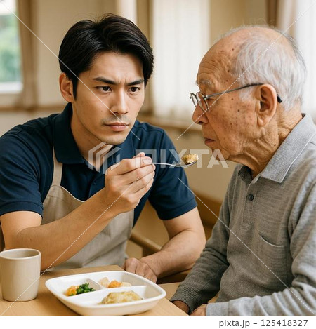 真剣なまなざしで支える食事介助の現場 125418327