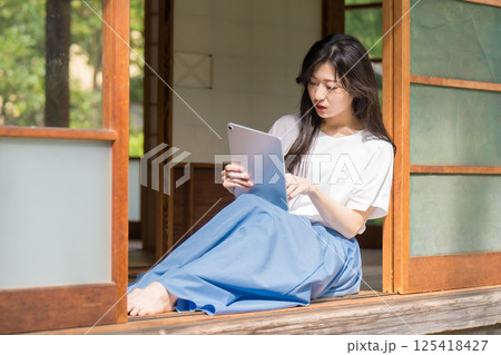 タブレット見てタッチ操作している若い女性 タブレット見てタッチ操作している若い女性 125418427