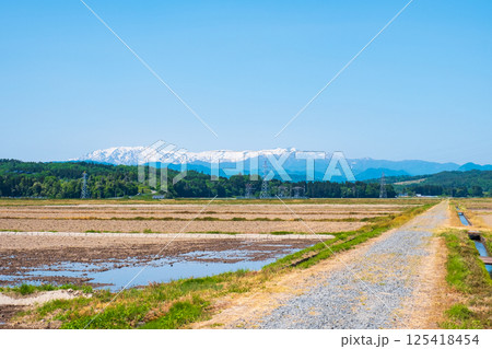 会津盆地から望む飯豊山地（春） 125418454