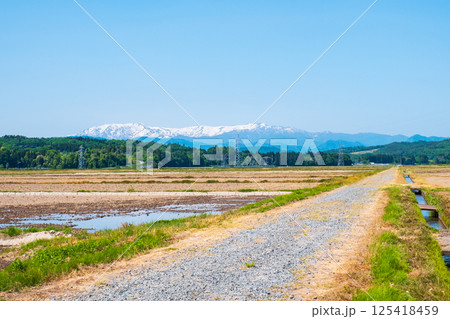 会津盆地から望む飯豊山地（春） 125418459