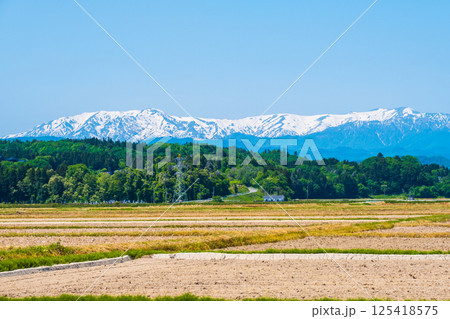 会津盆地から望む飯豊山地（春） 125418575