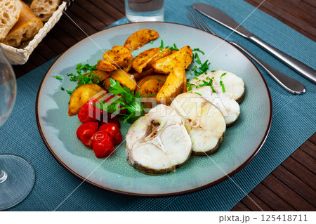 Country style baked merluccius steaks with potato 125418711