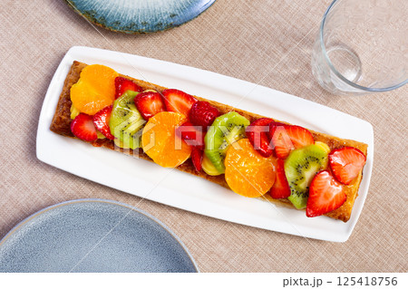 Puff pastry cake with custard, tangerine, kiwi and strawberry Puff pastry cake with custard, tangerine, kiwi and strawberry 125418756