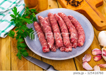 Raw longaniza from minced pork on plate. Popular Catalan sort of sausages Raw longaniza from minced pork on plate. Popular Catalan sort of sausages 125418760
