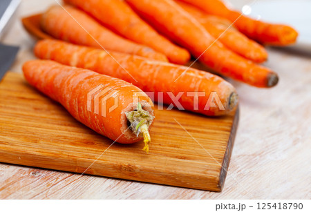 Raw unpeeled carrots on wooden table Raw unpeeled carrots on wooden table 125418790