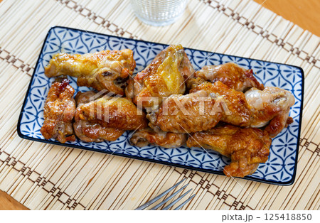 Service plate containing delicious fried chicken wings with necessary table laying closeup Service plate containing delicious fried chicken wings with necessary table laying closeup 125418850