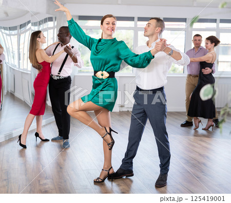 Woman and young man practicing waltz in dancing studio 125419001