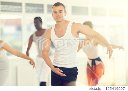 Concentrated women and men rehearsing ballet dance in class Concentrated women and men rehearsing ballet dance in class 125419007