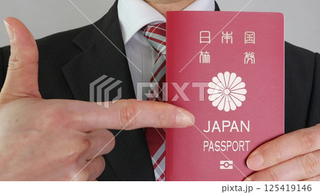 10年有効な日本のパスポートを指差すビジネスマン	 125419146