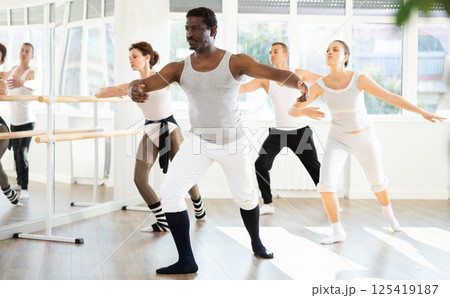 African American man leading ballet class with amateur dancers 125419187