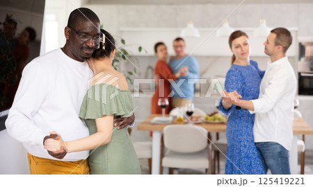 Black man enjoying slow dance with woman at house party 125419221