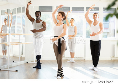 Group of men and women stand in third position 125419271