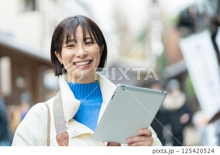昔ながらの街並みを見る女性　旅行をするコートの女性　一人旅 125420524