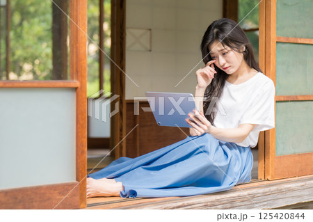 タブレットで動画を見ながら泣く若い女性 125420844