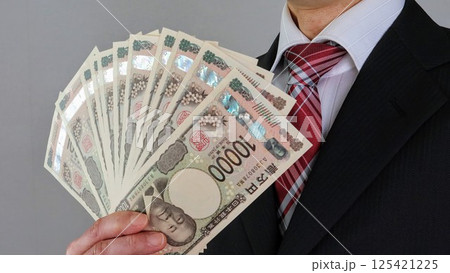 日本の新一万円札を持つビジネスマン 日本の新一万円札を持つビジネスマン 125421225