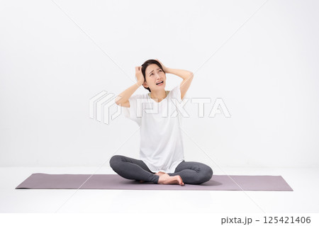 ヨガをする女性　ミドル　頭を抱える 125421406
