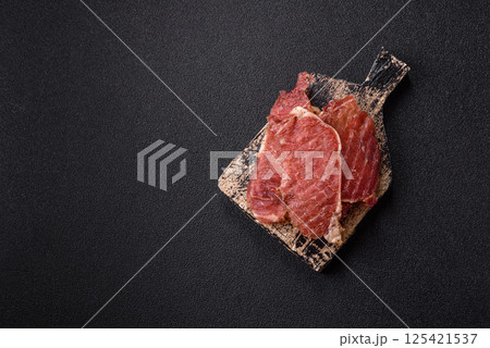 Jerky, dried pork meat slices with salt and spices 125421537