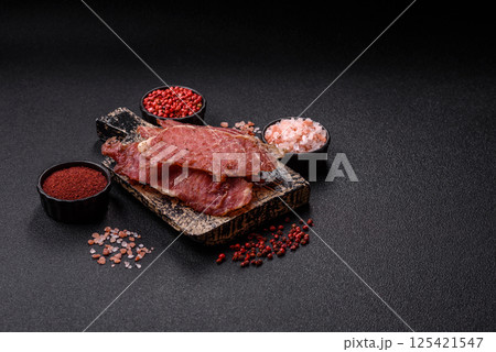 Jerky, dried pork meat slices with salt and spices Jerky, dried pork meat slices with salt and spices 125421547