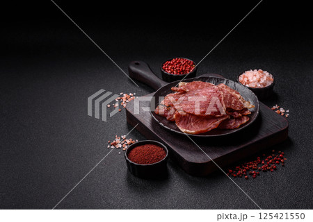Jerky, dried pork meat slices with salt and spices Jerky, dried pork meat slices with salt and spices 125421550