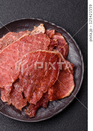 Jerky, dried pork meat slices with salt and spices 125421559