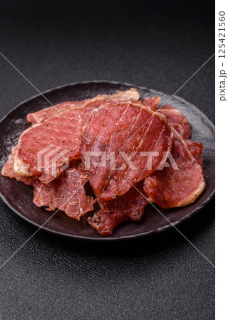 Jerky, dried pork meat slices with salt and spices 125421560