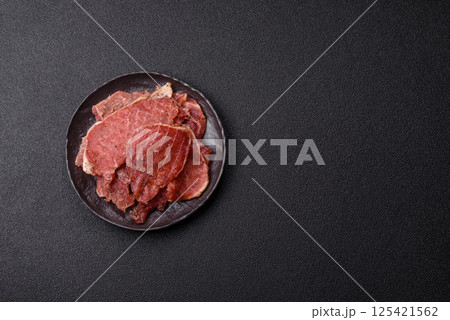 Jerky, dried pork meat slices with salt and spices Jerky, dried pork meat slices with salt and spices 125421562