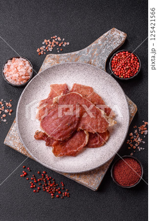 Jerky, dried pork meat slices with salt and spices Jerky, dried pork meat slices with salt and spices 125421566