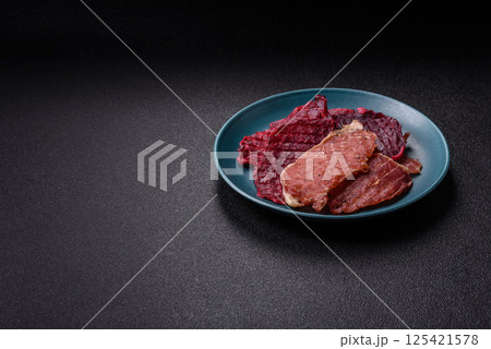 Jerky, dried pork meat slices with salt and spices 125421578