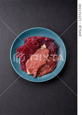 Jerky, dried pork meat slices with salt and spices 125421580