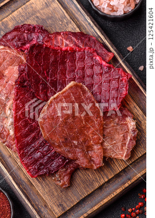 Jerky, dried pork meat slices with salt and spices 125421604