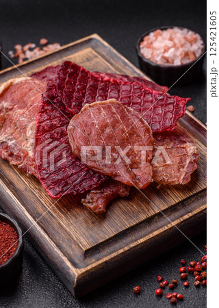 Jerky, dried pork meat slices with salt and spices Jerky, dried pork meat slices with salt and spices 125421605