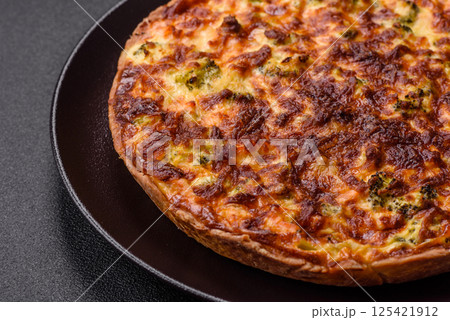 Delicious fresh quiche with broccoli, cheese, spices and herbs 125421912