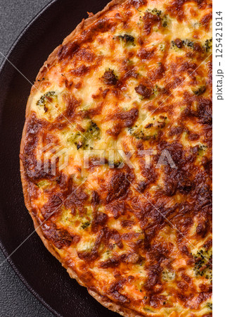 Delicious fresh quiche with broccoli, cheese, spices and herbs 125421914