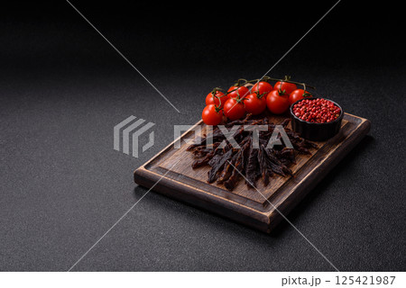 Jerky, dried horse meat or beef slices with salt and spices Jerky, dried horse meat or beef slices with salt and spices 125421987