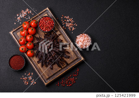 Jerky, dried horse meat or beef slices with salt and spices 125421999