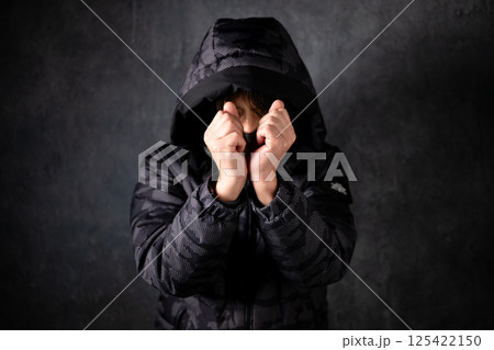 フードを深く被った男性 125422150