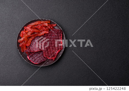 Dried beef slices, jerky, with cherry or plum flavor, salt and spices 125422248