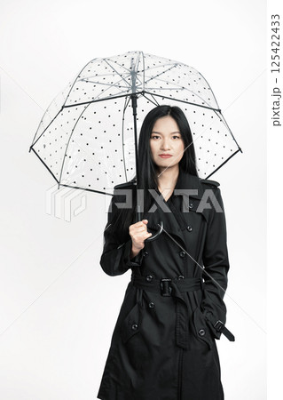 Asian woman with black burberry skirted trench coat and umbrella 125422433