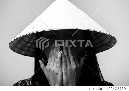 Portrait of Asian woman with cone-shaped Asian cane hat 125422439