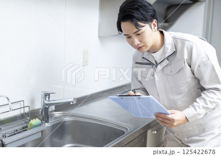 住宅営業　キッチンの点検をする男性　 125422678