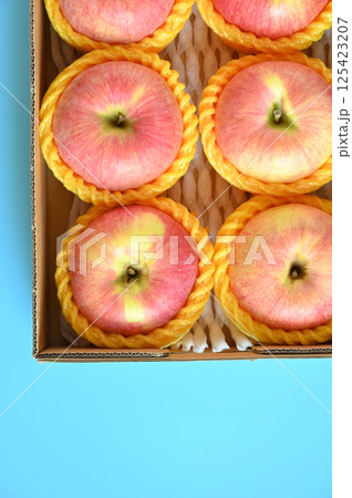 beautiful pink apple in the box on blue background 125423207