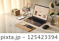 12Next Modern workspace featuring a laptop displaying an online shopping site. 125423394