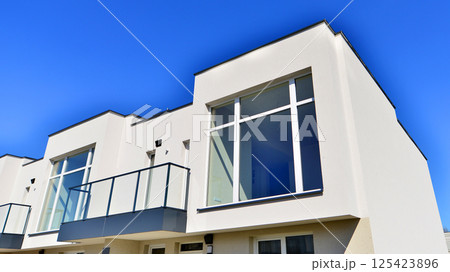 Terraced family homes in newly developed housing estate. The real estate market in the suburbs. New single family houses in a new development area. Residential homes with modern facade. Terraced family homes in newly developed housing estate. The real estate market in the suburbs. New single family houses in a new development area. Residential homes with modern facade. 125423896