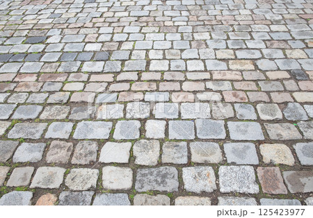 Granite cobblestone pavement. Ancient road surface. Stone sidewalk 125423977
