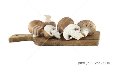 Several fresh cremini mushrooms, both whole and sliced in half, sit on a small wooden cutting board. Several fresh cremini mushrooms, both whole and sliced in half, sit on a small wooden cutting board. 125424240