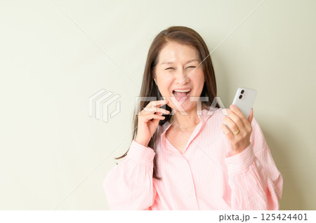 スマホを手に持つシニア女性 125424401